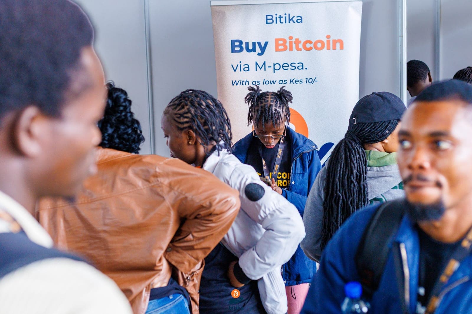 People at the Bitika booth beneath a 'Buy Bitcoin via M-Pesa from KES 10' banner